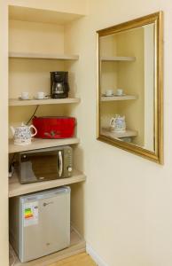 a mirror hanging on a wall next to a microwave at Hotel Aranjuez in Chillán