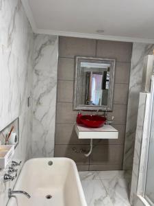 uma casa de banho com um lavatório branco e um espelho. em General Roca hermosa habitacion con baño privado em General Roca