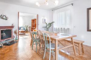 a dining room with a table and chairs and a fireplace at Tuyo Casa Sarabandy in Warsaw