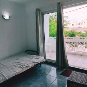 a bedroom with a bed and a large window at White Sand Cabana in Flic-en-Flac +51 photos
