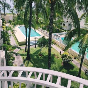 uma vista para a piscina a partir da varanda de um resort em White Sand Cabana em Flic-en-Flac