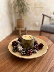 a plate with a candle and pine cones on a table at Refugio da Longueira in Longueira