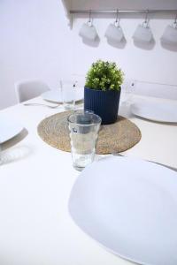 une table blanche avec une plante en verre dans l'établissement Living-Life, Klinik & Messe vor Ort, Wlan, Netflix, à Essen
