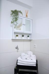 une salle de bains avec une étagère et des serviettes sur un tabouret dans l'établissement Living-Life, Klinik & Messe vor Ort, Wlan, Netflix, à Essen
