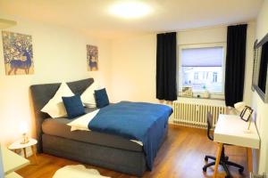 a bedroom with a bed and a desk and a window at Living-Life, Klinik & Messe vor Ort, Wlan, Netflix in Essen