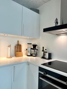een keuken met witte kasten en een fornuis met oven bij Luxury New Cozy and Quietly 95m2 in Tórshavn