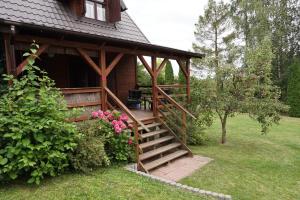a house with a wooden staircase leading to a porch at Domek letniskowy Fuleda in Fuleda