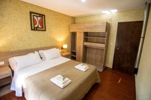 1 dormitorio con 1 cama con 2 toallas en Ayres de Uco Lodge & Wine Lovers en Los Árboles