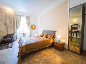 a bedroom with a bed and a chair and a television at Opera apartments - Mestský palác in Banská Štiavnica