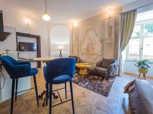 a living room with a couch and a table and chairs at Opera apartments in Banská Štiavnica