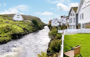a river in a village with white houses at 1 Bedroom Stunning Apartment In Hauge I Dalane in Sogndalsstrand