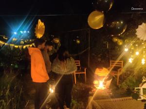 a group of people standing in a yard at night at Shoonya Mukteshwar in Mukteswar