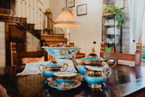 a table with three tea pots and a bowl on it at B&B Vicidomini in San Marco dei Cavoti