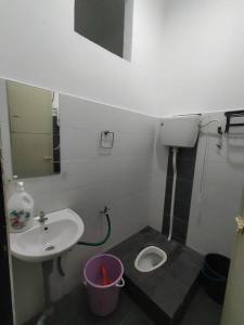 ein kleines Bad mit einem Waschbecken und einem WC in der Unterkunft A YIE HOMESTAY in Kuantan