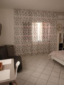 um quarto com uma cama e uma janela com uma cortina em Casa Lavinia al mare em Rimini