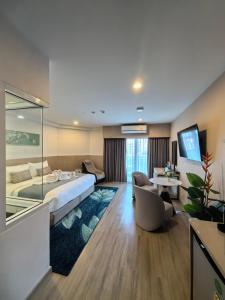 a hotel room with a large bed and a couch at Chinatown Living Hatyai in Hat Yai