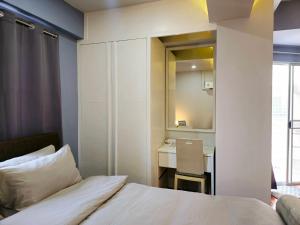 1 dormitorio con cama, escritorio y espejo en T Room Jomtien en Jomtien Beach