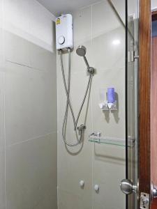 a shower with a shower head in a bathroom at T Room Jomtien in Jomtien Beach