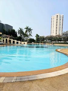 a large swimming pool with blue water in a city at T Room Jomtien in Jomtien Beach
