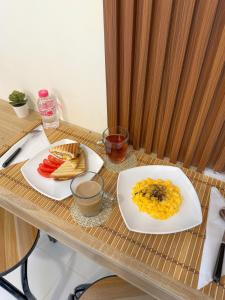 a wooden table with two plates of food on it at RksHome Studio Apartment Baniyas Metro Exit 2 in Dubai