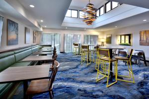 - une salle à manger avec des tables, des chaises et des fenêtres dans l'établissement Fairfield Inn & Suites by Marriott Charlottesville North, à Charlottesville