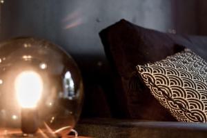 een kaars in een glazen bol naast een kussen bij Superbe studio style industriel à Charbonnière in Charbonnières-les-Bains