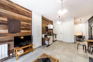 een woonkamer met een grote houten muur bij Superbe studio style industriel à Charbonnière in Charbonnières-les-Bains