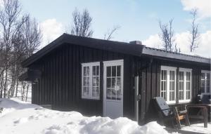 a small cabin with a door in the snow at 3 Bedroom Stunning Home In Uvdal in Uvdal +6 photos