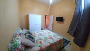 a small bedroom with a bed and a cabinet at Southern Haven Beach House in Laborie