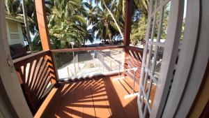 an open door to a balcony with palm trees at Southern Haven Beach House in Laborie