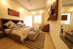 a bedroom with a bed and a couch and a television at Perfect Stayz Hills in Rishīkesh