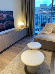 een woonkamer met een bed en een televisie bij Luxe appartement `t Sant Nieuwpoort Bad in Nieuwpoort