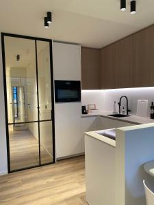 een keuken met een koelkast en een wastafel bij Luxe appartement `t Sant Nieuwpoort Bad in Nieuwpoort