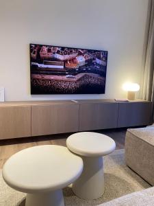 a living room with a white table and a tv at Luxe appartement `t Sant Nieuwpoort Bad in Nieuwpoort