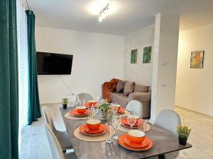a dining room with a table with chairs and a couch at Luxury Glam Apartments Sibiu near Station and Mall in Sibiu