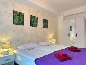 a bedroom with a large bed with red towels on it at Luxury Glam Apartments Sibiu near Station and Mall in Sibiu