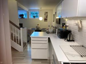 een keuken met witte toonbanken en witte kasten bij Bullseye Kristiansand in Kristiansand