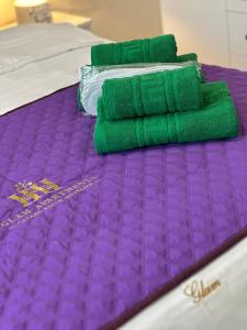 eine Gruppe grüner und violetter Bettwäsche auf einem Bett in der Unterkunft Luxury Apartments Sibiu near Station and Mall with Parking in Sibiu