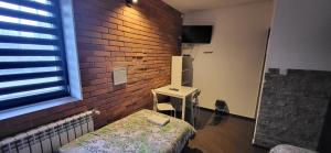 Pokój z łóżkiem i ceglaną ścianą w obiekcie M Hostel w mieście Gliwice