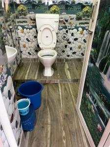 een badkamer met een toilet en een muur bij RATNA NIBAS 