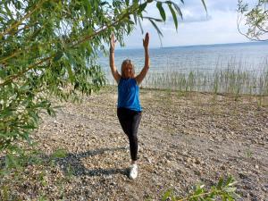 Una donna in piedi sulla spiaggia con le mani in alto di ANNA Gästehaus Zimmer a Pfreimd