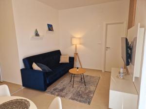 a living room with a blue couch and a table at Apartment Ana - Gradac in Gradac