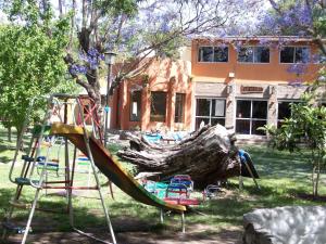 un parque infantil con un tobogán frente a una casa en Cabañas El Paraiso en San Marcos Sierras