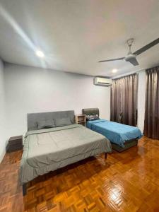 - une chambre avec 2 lits et un ventilateur de plafond dans l'établissement 1717Homestay@Riveria@12pax, à Kuching