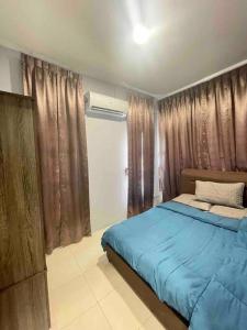 - une chambre avec un lit doté de draps bleus et de rideaux dans l'établissement 1717Homestay@Riveria@12pax, à Kuching