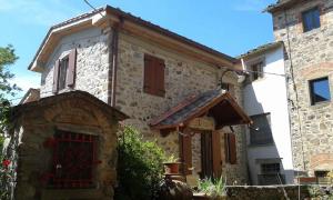 una casa in pietra con una porta rossa davanti di Holiday home in Marliana - Toskana 48269 a Marliana