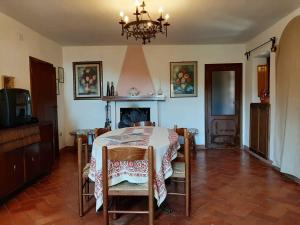 una sala da pranzo con tavolo e camino di Holiday home in Marliana - Toskana 48269 a Marliana