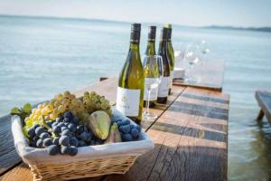 a basket of grapes and wine bottles on a table at Studio in Csopak - Balaton 48108 in Csopak +15 photos