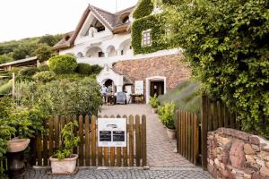 a house with a sign in front of a fence at Studio in Csopak - Balaton 48108 in Csopak