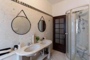 アラッシオにあるApartment in Alassio - Ligurische Riviera 48200のバスルーム(洗面台2台、シャワー、鏡付)